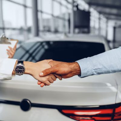 woman-car-seller-man-car-buyer-handshaking-car-salon_93675-123537